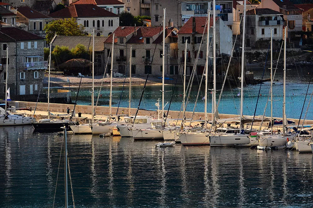 Sailing boats tied to the pier in the bay of Komiža on the island of Vis