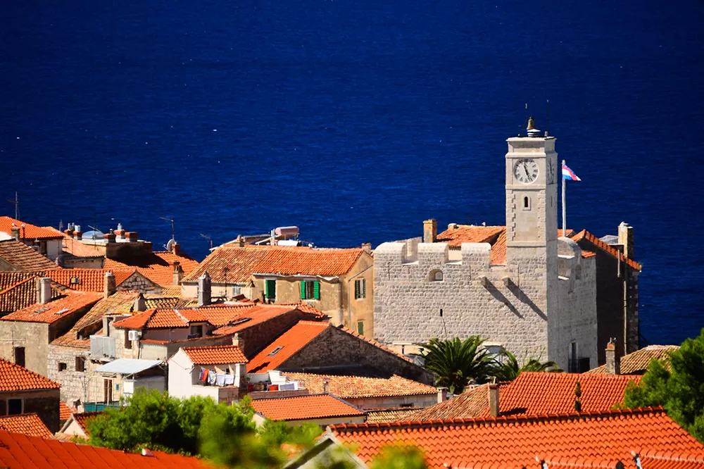 The roofs of the town of Komiža and the castle Grimaldi with the blue sea in the background