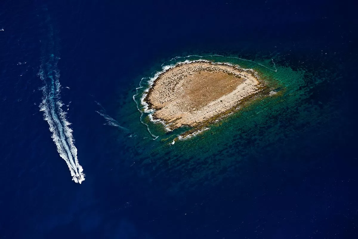 A small island bordered by the sea is part of the Vis archipelago